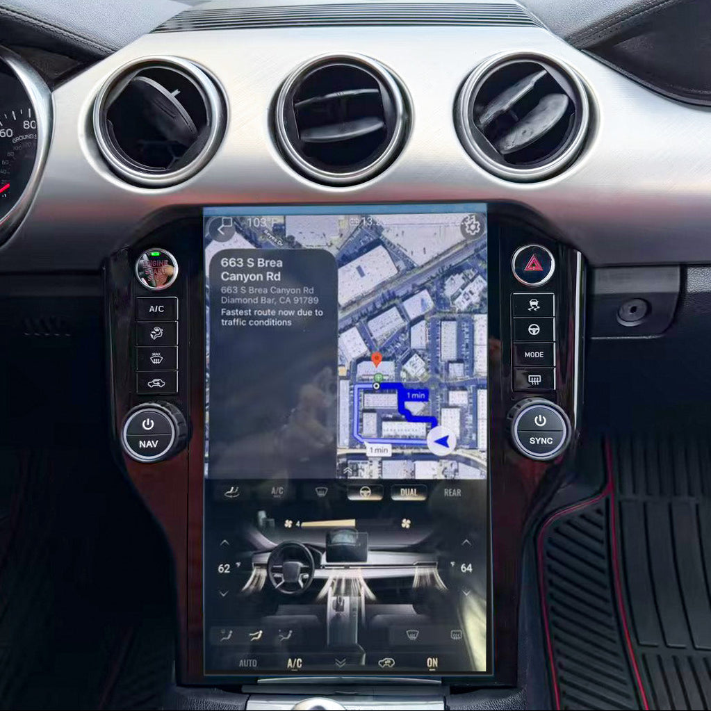 A close-up of a car's dashboard and center console, featuring a large vertical touchscreen display showing a map and vehicle controls, with circular air vents and silver trim.